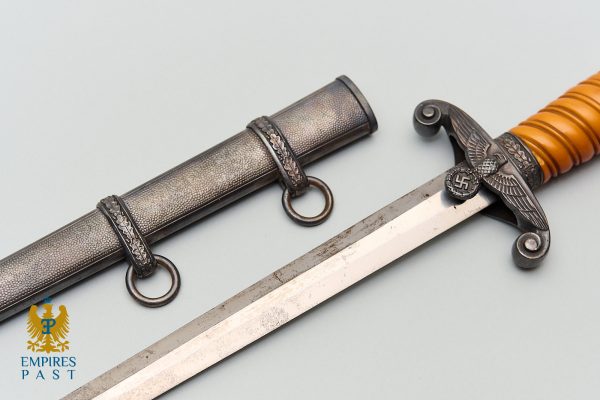WWII German ceremonial dagger with a leather-wrapped handle, eagle insignia holding a swastika, and a decorative sheath on a pale background.
