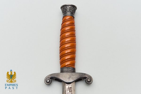 Close-up of a dagger with an orange spiral grip and ornate steel guard, blade stamped 'ORIGINAL'.