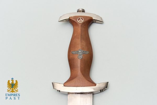 World War II dagger with a brown wooden grip, silver crossguard, and a swastika beneath an eagle emblem on the handle area.