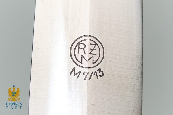 Close-up of a steel blade with a circular maker's mark containing RM and MZ initials.