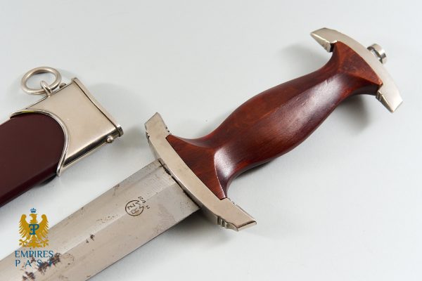Dagger with a dark wooden handle and metal guard on a pale surface, logo reading 'Empires Past' in the lower-left corner.