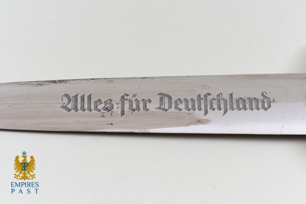 Close-up of a metal blade with Gothic inscription 'Alles für Deutschland'; Empires Past logo bottom-left.