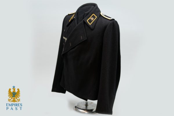 Headless mannequin wearing a black military-style coat with gold shoulder insignia on a display stand; logo 'Empires Past' in bottom left corner.