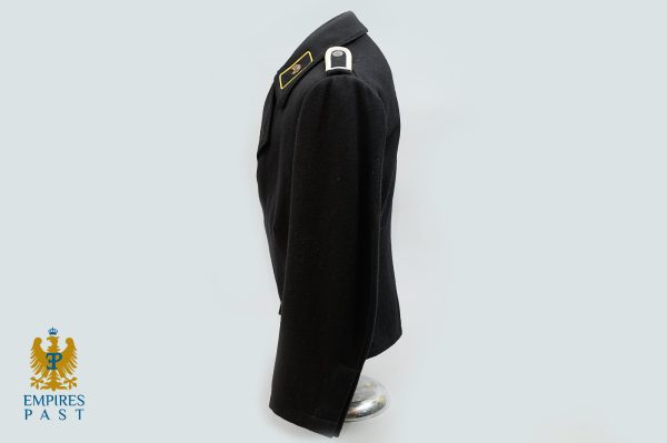 Side-profile of a black military jacket on a mannequin, with gold-edged shoulder insignia; Empires Past logo lower left corner