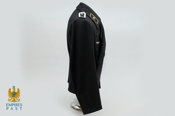 Black military coat displayed on a side-view mannequin, features gold collar insignia and epaulettes, with Empires Past logo in the bottom-left corner.