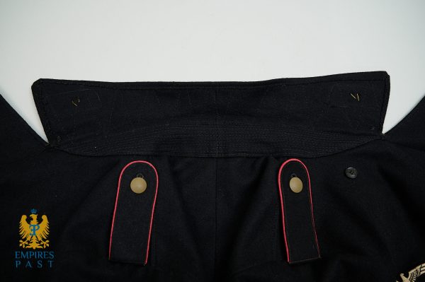 Close-up of a black military-style coat collar with red-edged straps and brass buttons; Empires Past emblem in the bottom left corner.