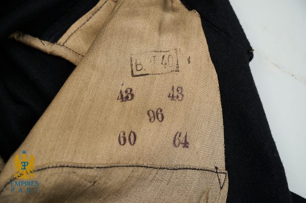 Interior of a black coat showing beige lining with size stamps: 48, 48, 60, 96 and a boxed mark above them; empire logo partially visible in corner