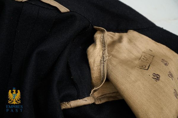 Close-up of black fabric with tan lining and a folded seam; logo for Empires Past visible bottom-left.