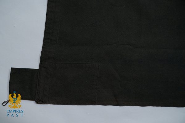 Black fabric laid flat showing a small rectangular pocket at the bottom left and a fabric tab with a metal clip; watermark reads EMPIRES PAST.