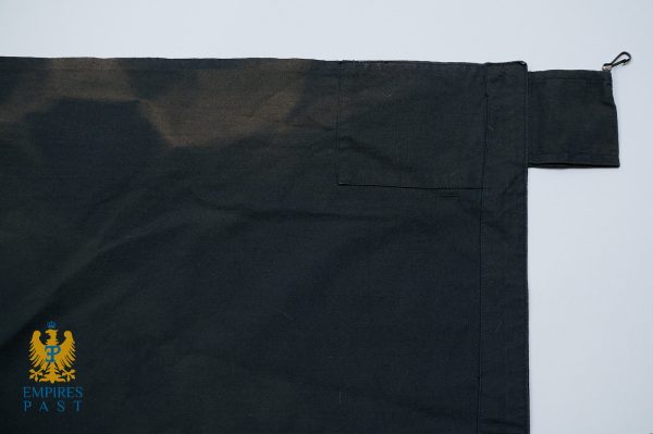 Dark fabric item with a small stitched pocket and the Empires Past crest logo in the bottom-left corner.