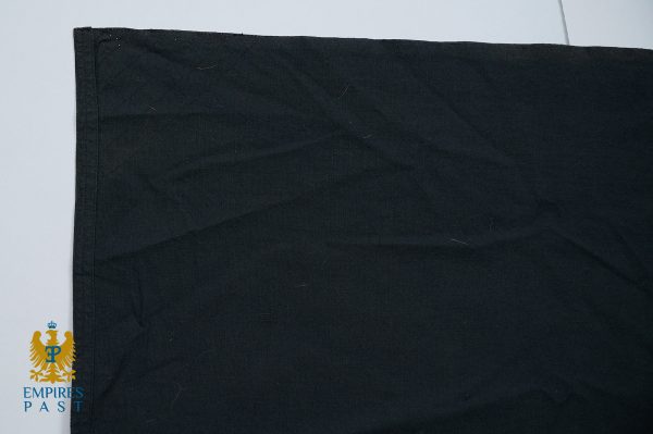 Black fabric swatch with a left edge seam, featuring a blue and gold Empire’s Past logo in the bottom-left corner
