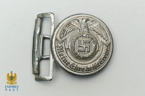 Metal belt buckle showing an eagle above a swastika enclosed in a wreath, with German inscription around the edge (Nazi-era insignia).