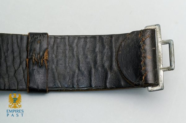 Worn black leather belt with a silver metal buckle, showing creases and frayed stitching along the strap edge.