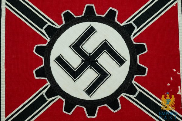 Propaganda flag showing a white-circle black swastika on a red field with a gear-like border (Nazi symbol).