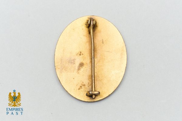 Empires Past 202517293 - Empires Past Back of an oval gold medal with a vertical pin and clasp at top, shown on a pale background; Emperies Past logo in lower-left corner.