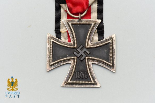 German Iron Cross 1939 medal hanging from red-white-black ribbon, front view with swastika at center and engraved date 1939 on the bottom arm.