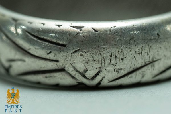 Close-up of a heavily scratched, worn silver ring surface; Empires Past watermark visible in the lower-left corner.