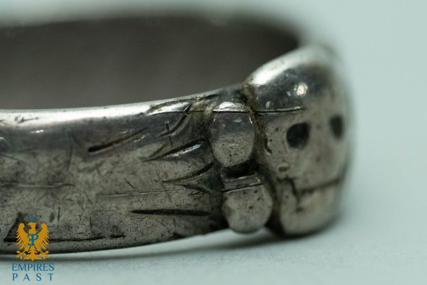 Close-up of a tarnished silver bracelet joint with scratches and a worn surface.