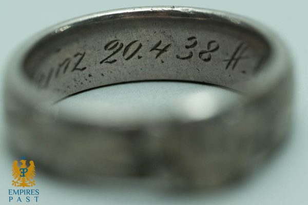 Close-up of the inside of a silver ring with the engraved inscription '2014 38' along the inner band.